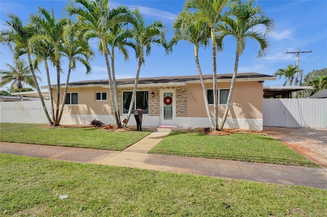 ranch-style home with a front yard, fence, and stucco siding