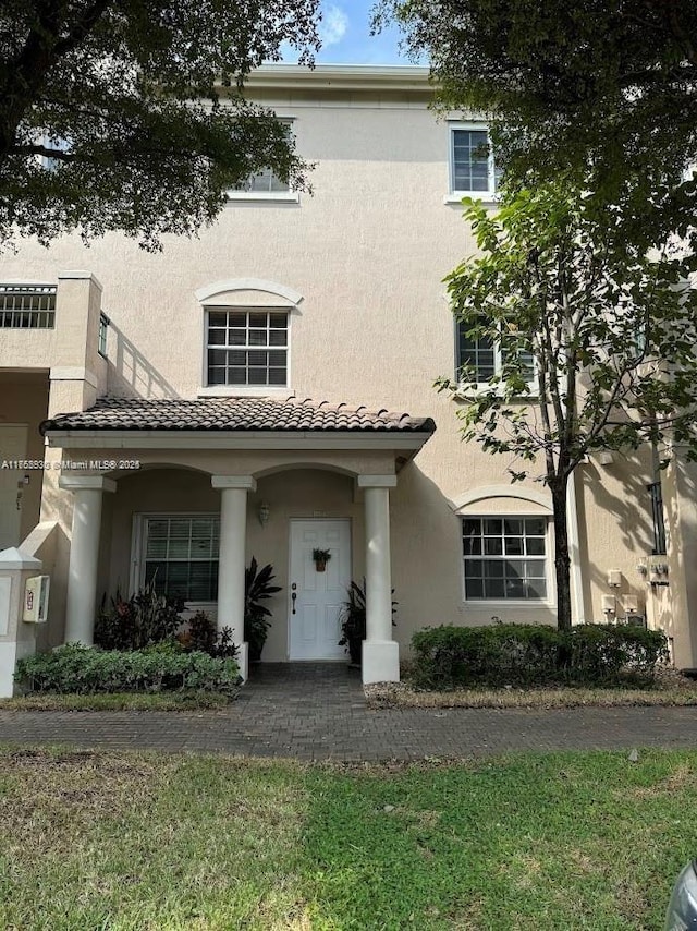 view of front facade featuring a tile roof and stucco siding