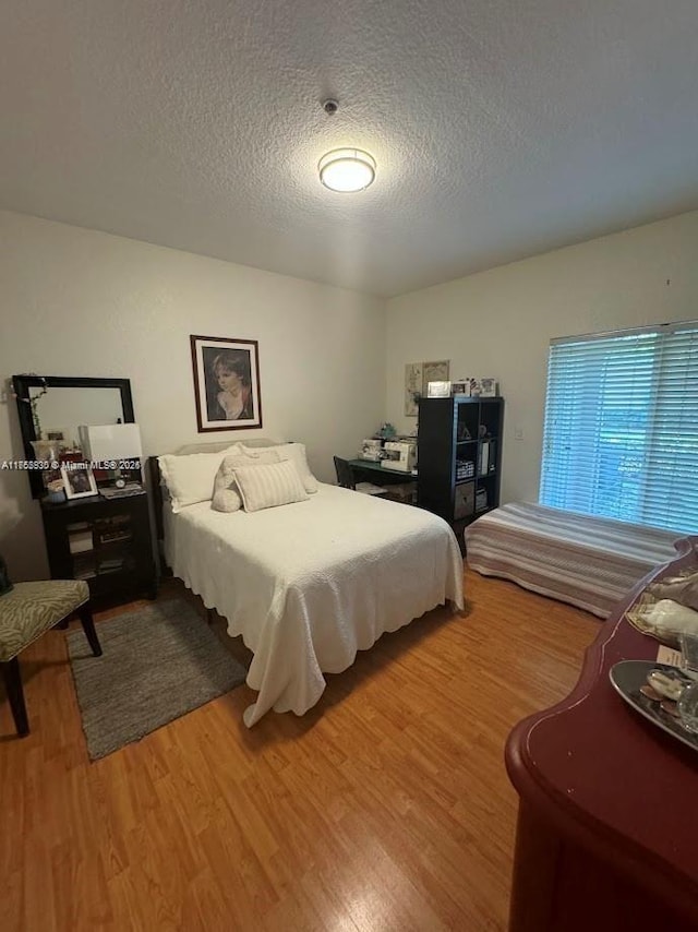 bedroom featuring a textured ceiling and wood finished floors