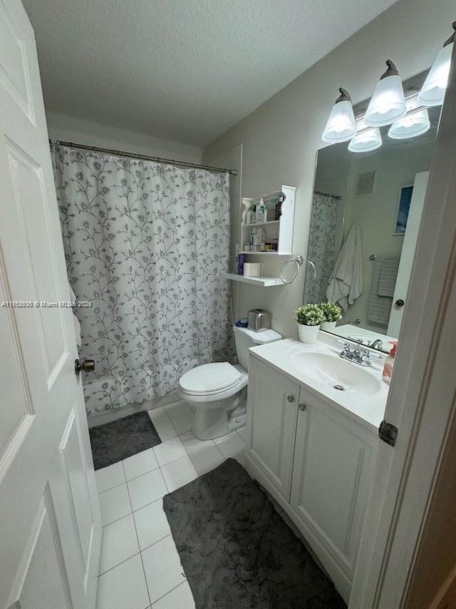 bathroom with a textured ceiling, tile patterned flooring, toilet, vanity, and visible vents