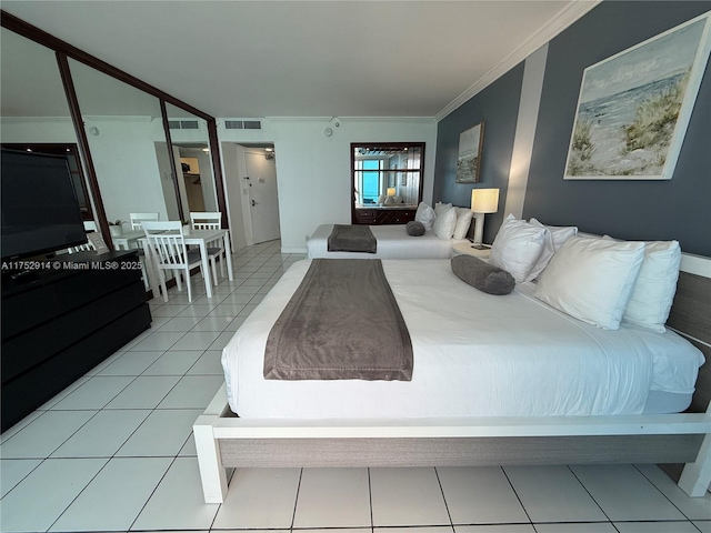 bedroom featuring light tile patterned floors, visible vents, and crown molding