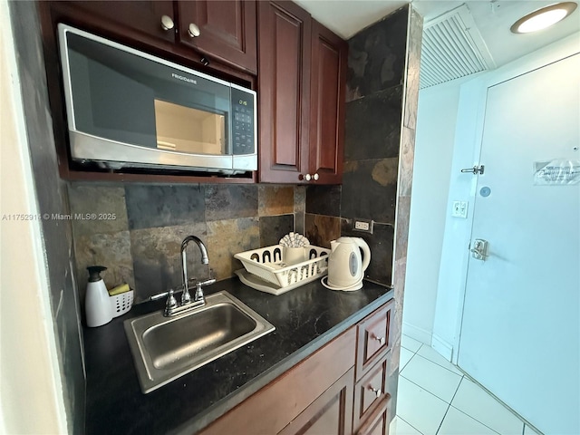 kitchen featuring a sink, backsplash, and light tile patterned floors