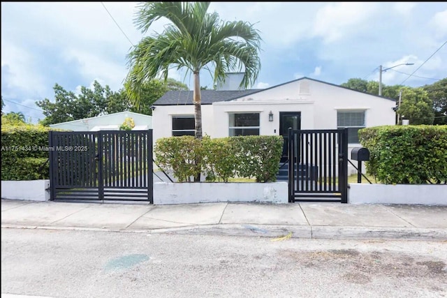 view of front of property with a fenced front yard, a gate, and stucco siding