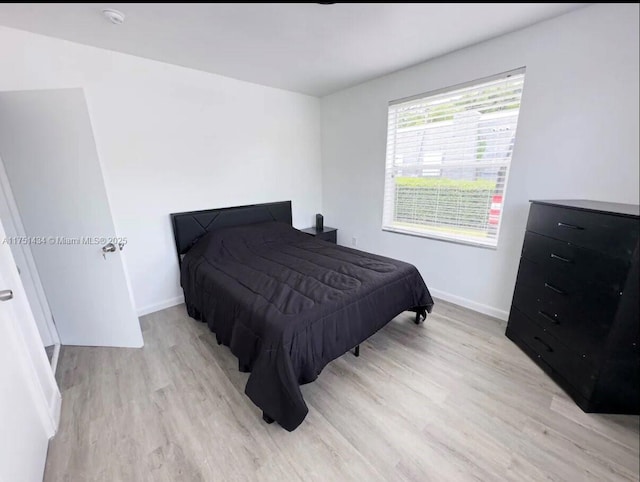 bedroom with light wood-style floors and baseboards