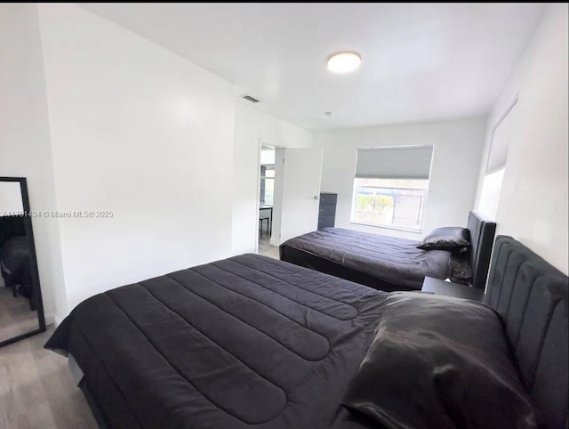 bedroom with wood finished floors and visible vents