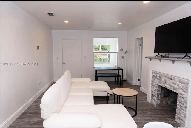 living room featuring a fireplace, baseboards, dark wood-type flooring, and recessed lighting