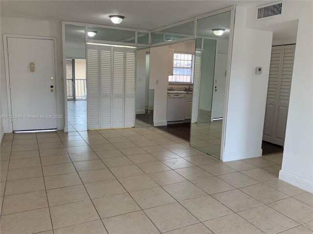 unfurnished room with light tile patterned floors, baseboards, and visible vents