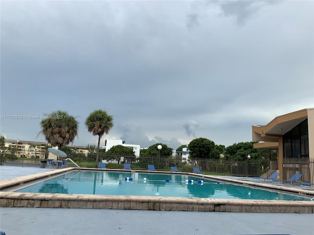 pool with a patio area and fence