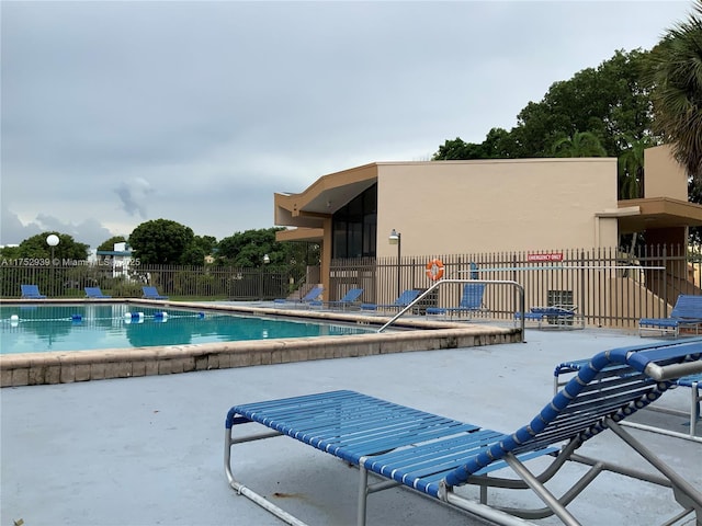 community pool featuring a patio area and fence