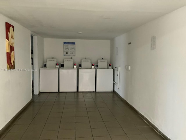 common laundry area featuring baseboards, dark tile patterned floors, and washing machine and clothes dryer