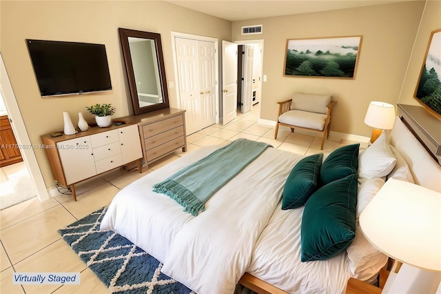 bedroom featuring baseboards, light tile patterned flooring, visible vents, and a closet