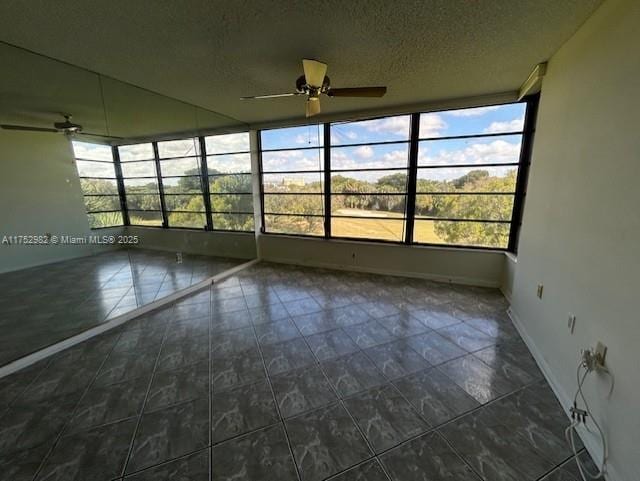 unfurnished sunroom featuring a ceiling fan