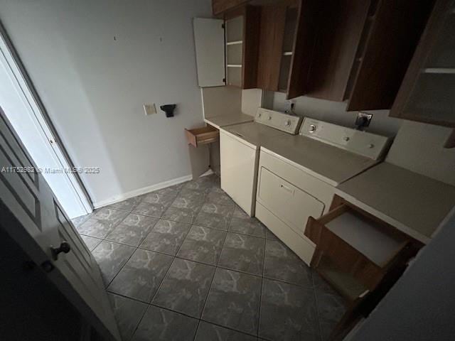 laundry room featuring washing machine and clothes dryer, cabinet space, and baseboards