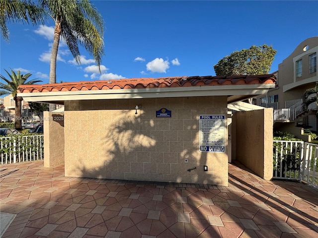 view of property exterior featuring a tiled roof and stucco siding