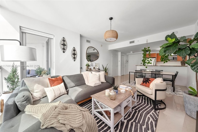 living area featuring light tile patterned floors and visible vents