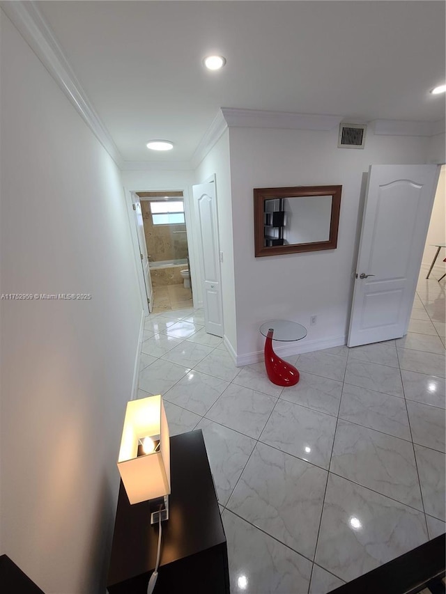 hall featuring baseboards, marble finish floor, visible vents, and crown molding