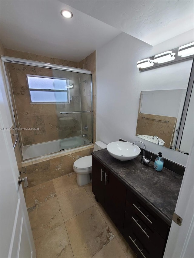 bathroom featuring tiled shower / bath combo, tile patterned flooring, toilet, and vanity