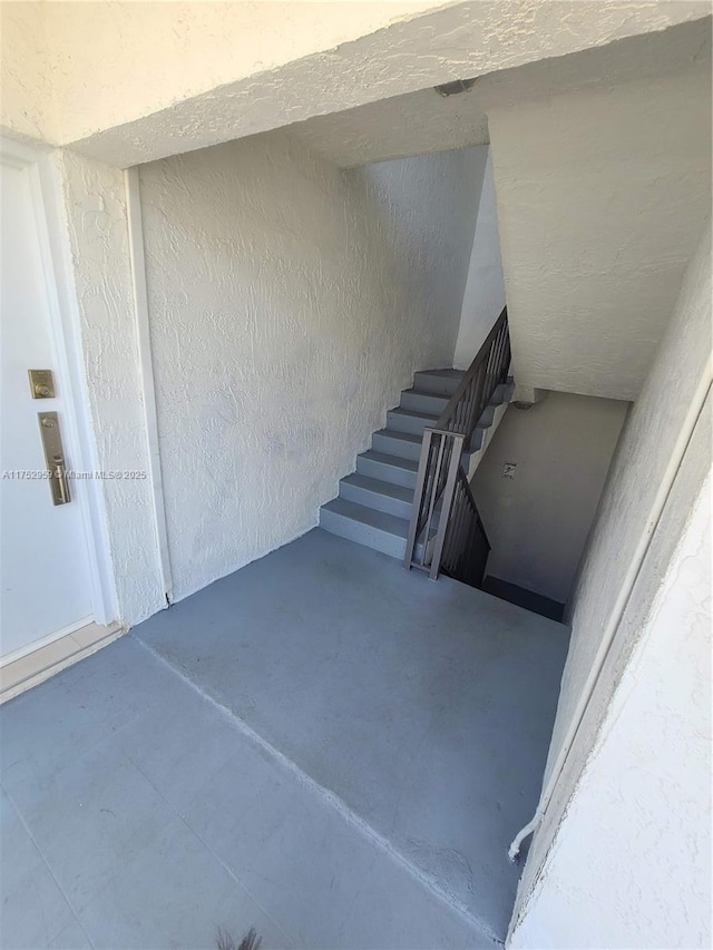 stairs with concrete flooring