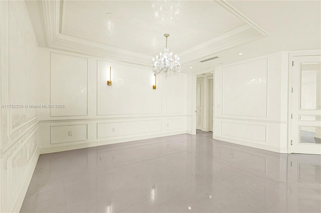 empty room with ornamental molding, a tray ceiling, visible vents, and a decorative wall