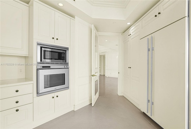 kitchen featuring recessed lighting, white cabinetry, light countertops, and built in appliances