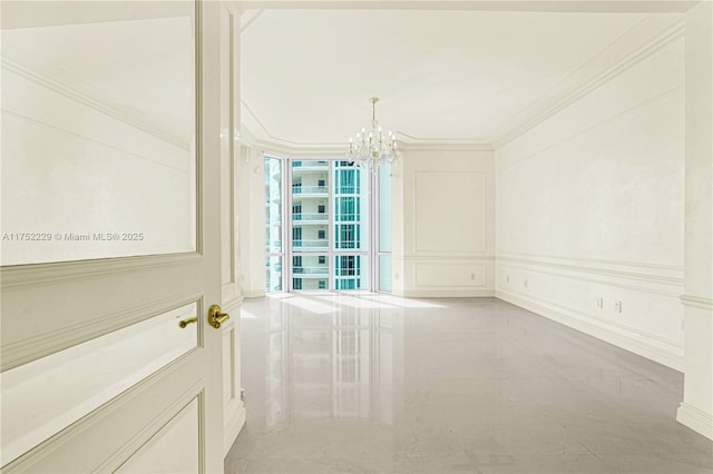 unfurnished room featuring a notable chandelier, a decorative wall, marble finish floor, a wall of windows, and crown molding