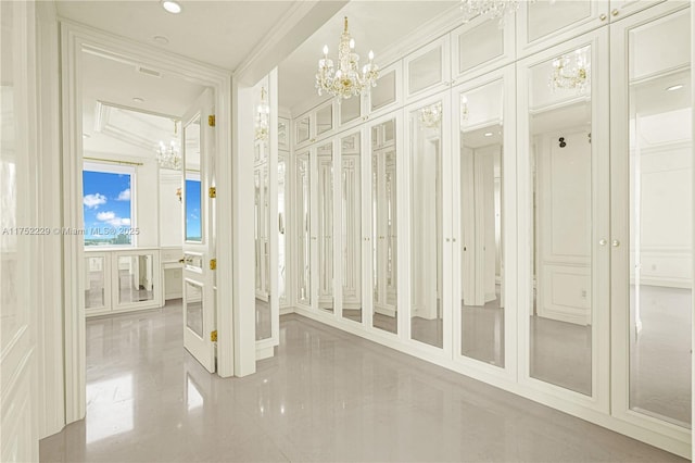 spacious closet featuring a chandelier and marble finish floor