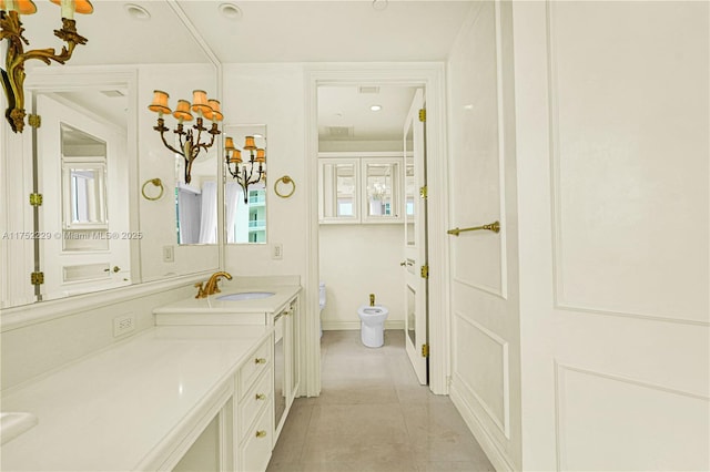 bathroom featuring toilet, tile patterned floors, baseboards, and vanity