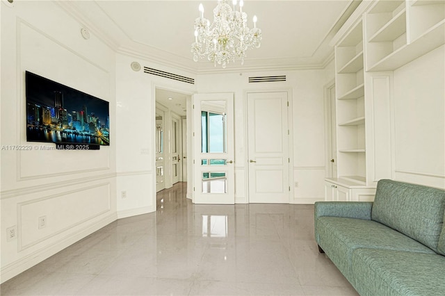 living area featuring built in shelves, a notable chandelier, visible vents, a decorative wall, and ornamental molding