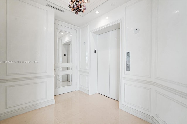 corridor with elevator, visible vents, a decorative wall, and light tile patterned floors