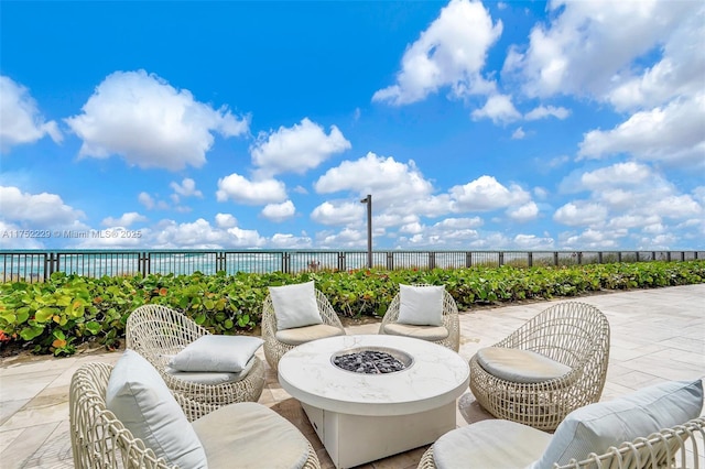 view of patio / terrace featuring an outdoor living space with a fire pit and fence