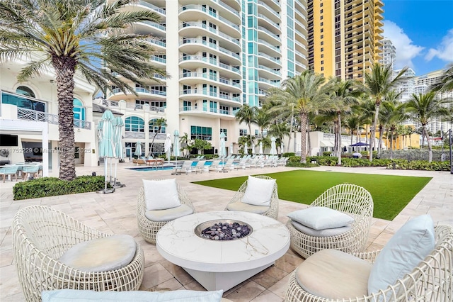 view of property's community featuring a fire pit, a pool, and a patio