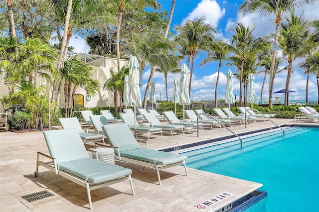 community pool featuring fence and a patio