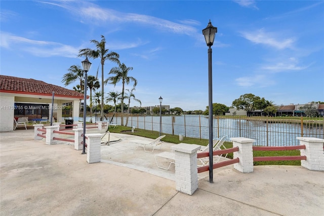 view of patio / terrace with a water view and fence