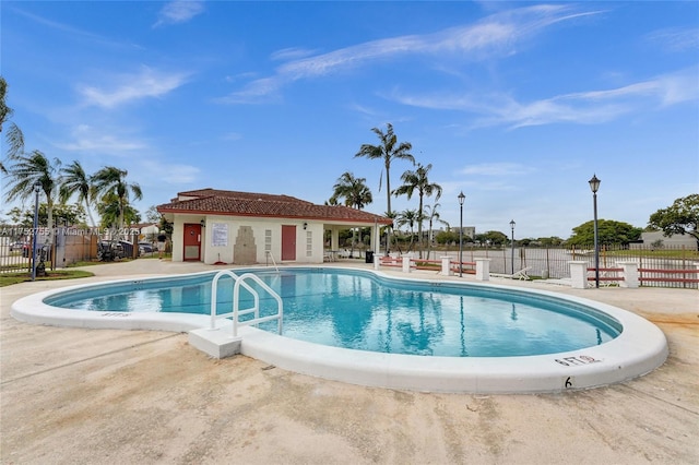 community pool with a patio and fence