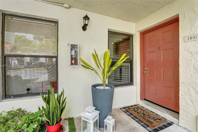 entrance to property featuring stucco siding