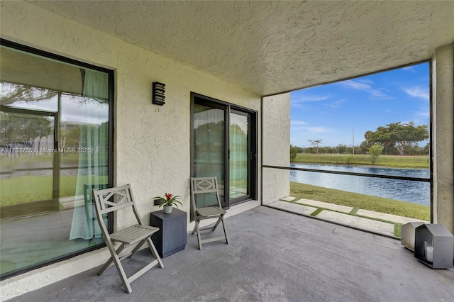 sunroom featuring a water view