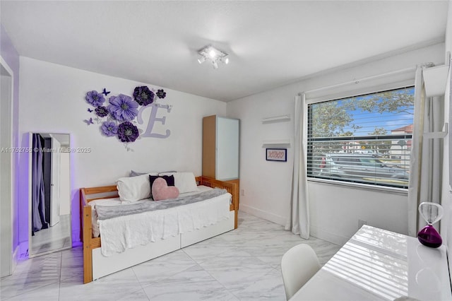 bedroom featuring marble finish floor and baseboards