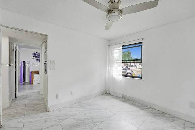 spare room featuring marble finish floor, ceiling fan, and baseboards