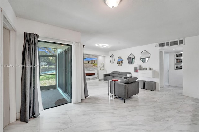 living room with marble finish floor, visible vents, and a large fireplace