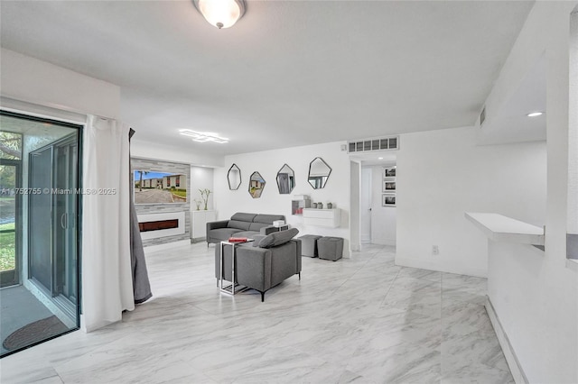 living area with marble finish floor, baseboards, a fireplace, and visible vents