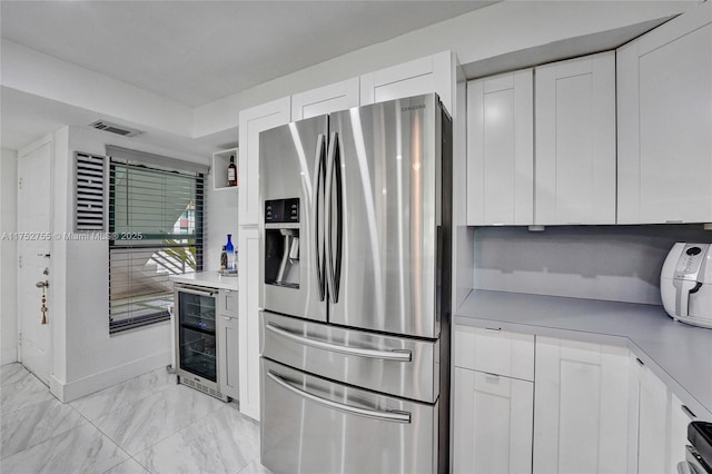 kitchen with wine cooler, light countertops, visible vents, white cabinetry, and stainless steel fridge with ice dispenser