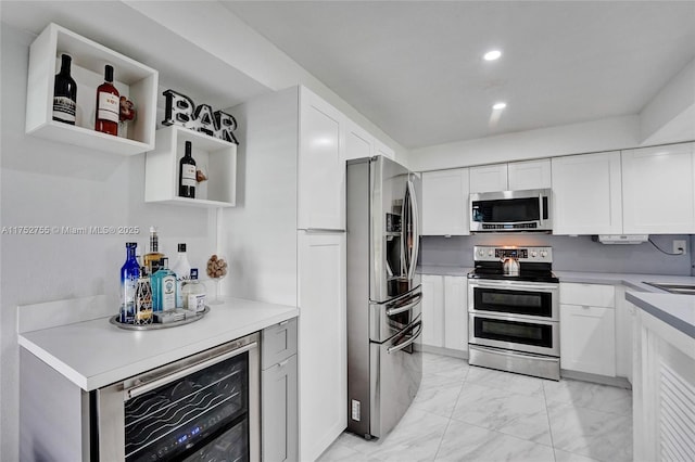 kitchen featuring wine cooler, appliances with stainless steel finishes, and white cabinets