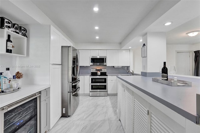 kitchen with appliances with stainless steel finishes, light countertops, and white cabinetry