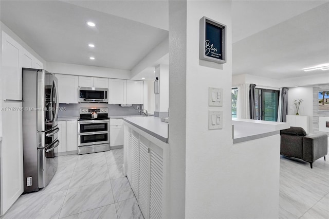 kitchen with stainless steel appliances, white cabinetry, open floor plan, light countertops, and marble finish floor