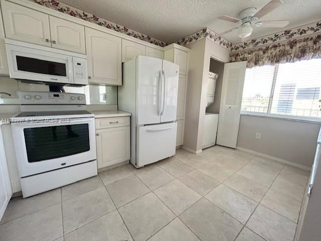 kitchen featuring a textured ceiling, white appliances, light countertops, light tile patterned floors, and ceiling fan