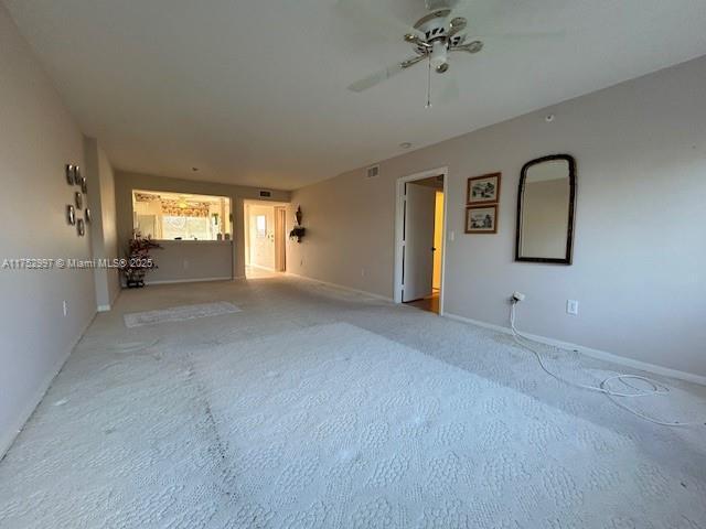 unfurnished room with carpet flooring, ceiling fan, and baseboards