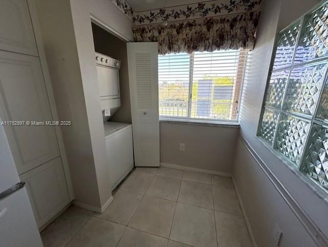 9525 Weldon Cir Unit H403, Fort Lauderdale, FL 33321 - laundry room with stacked washer / drying machine, light tile patterned flooring, and baseboards