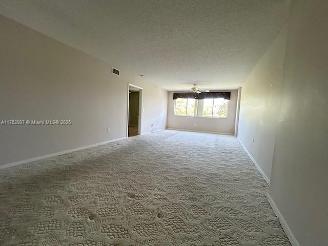 9525 Weldon Cir Unit H403, Fort Lauderdale, FL 33321 - carpeted spare room with baseboards and a textured ceiling
