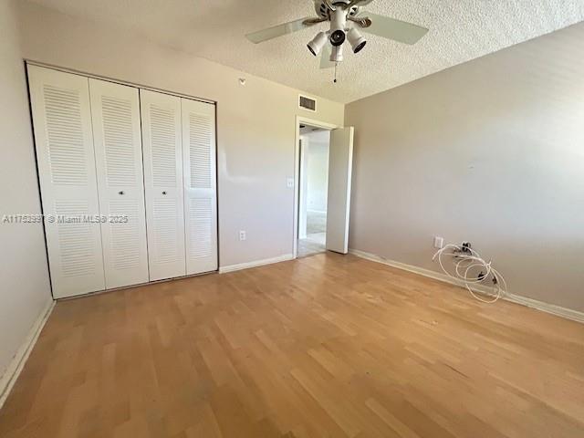 9525 Weldon Cir Unit H403, Fort Lauderdale, FL 33321 - unfurnished bedroom with wood finished floors, baseboards, and a closet