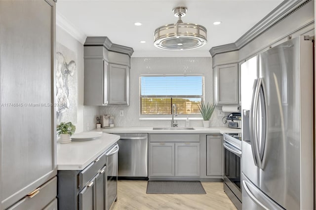 kitchen with gray cabinets, stainless steel appliances, a sink, and light countertops